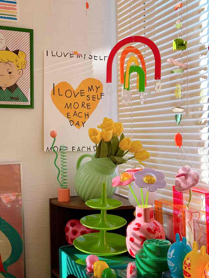 白いレンガ壁とブラインドを背景にした寝室ディスプレイ、カラフルな花瓶と飾りがレトロな雰囲気を醸し出す空間