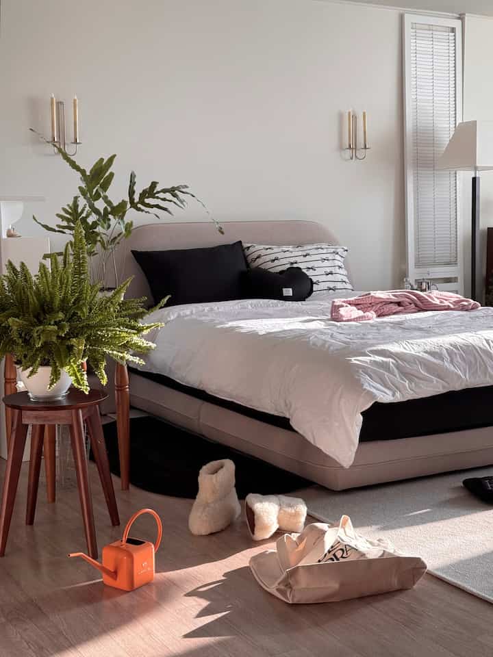 Beige and wood tone bedroom featuring bed frame and plants with a modern, natural atmosphere
