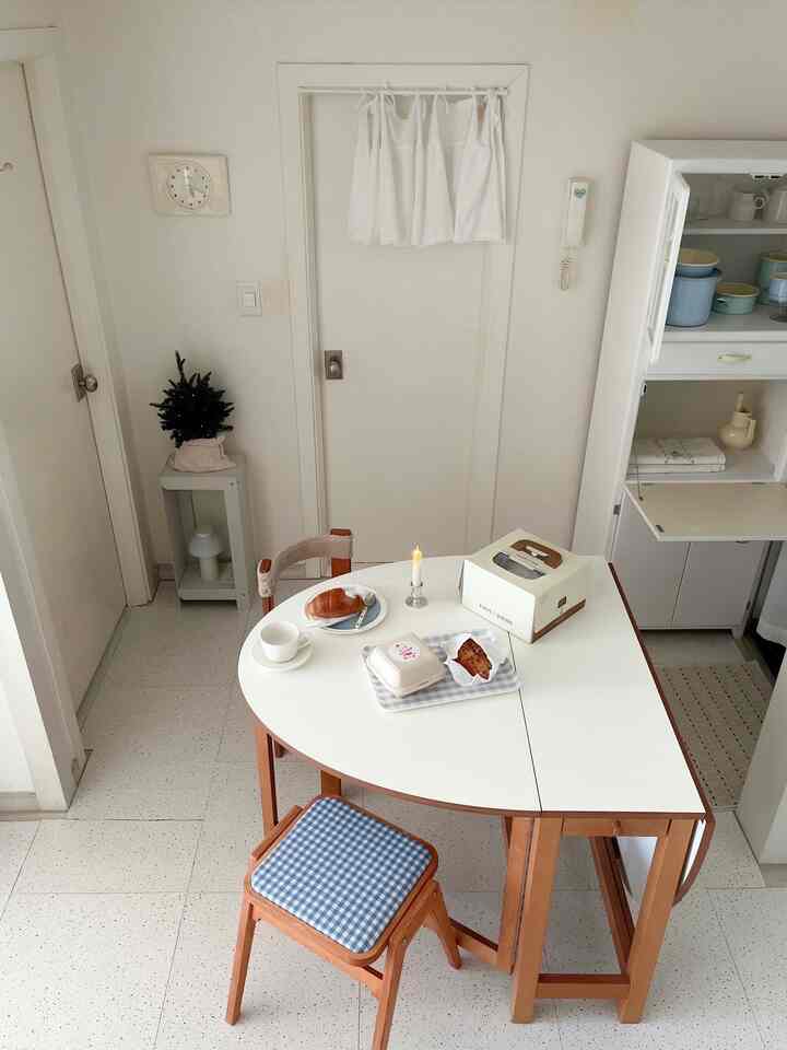 白を基調とした木目調家具のコンパクトなキッチンのダイニングスペース、おうちカフェの雰囲気が漂う清潔感のあるインテリア