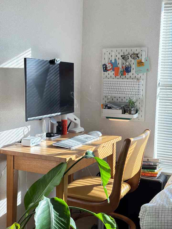 Bright white walls with wood-tone desk in a natural style single household home office space
