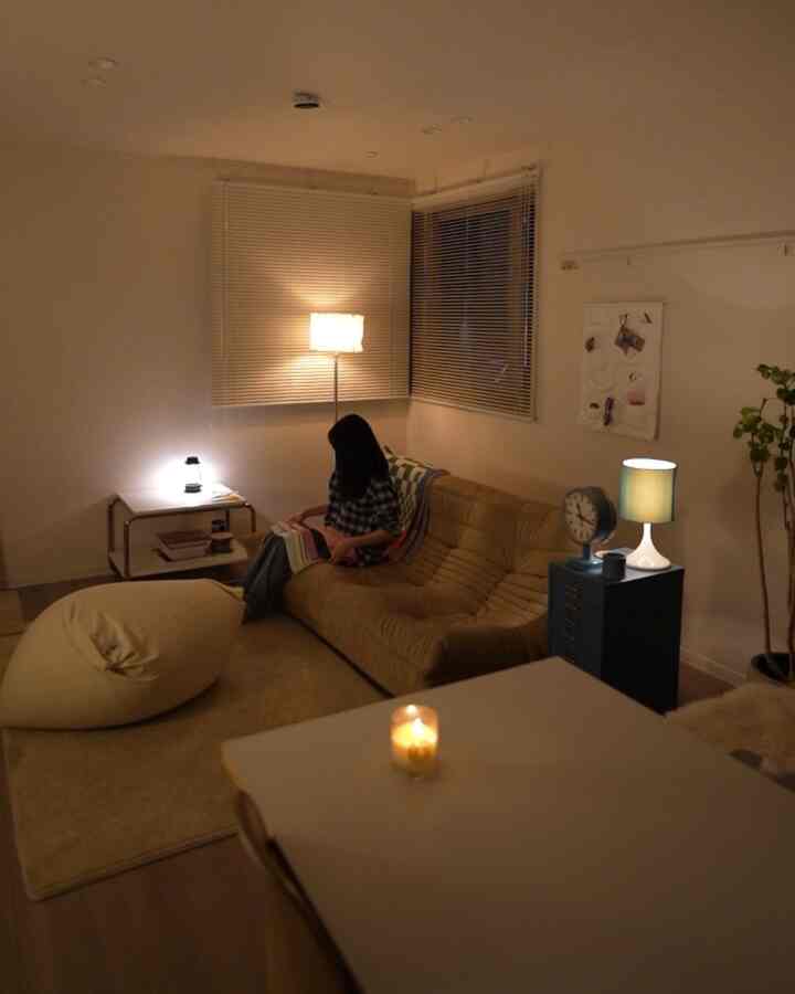 ベージュと木目調のリビング、ベージュのソファとビーンバッグ、温かみのある照明が配置された雰囲気のある空間
