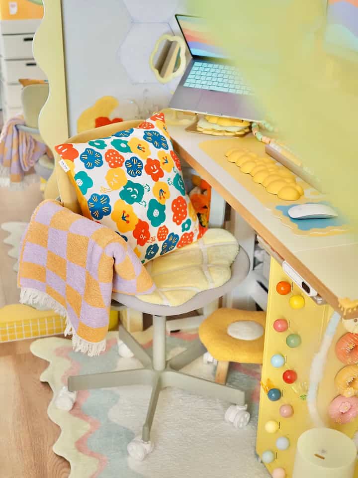 パステル調と黄色が調和したコンパクトなホームオフィス、カラフルな収納チェストと波形ラグが温かみのある空間を演出