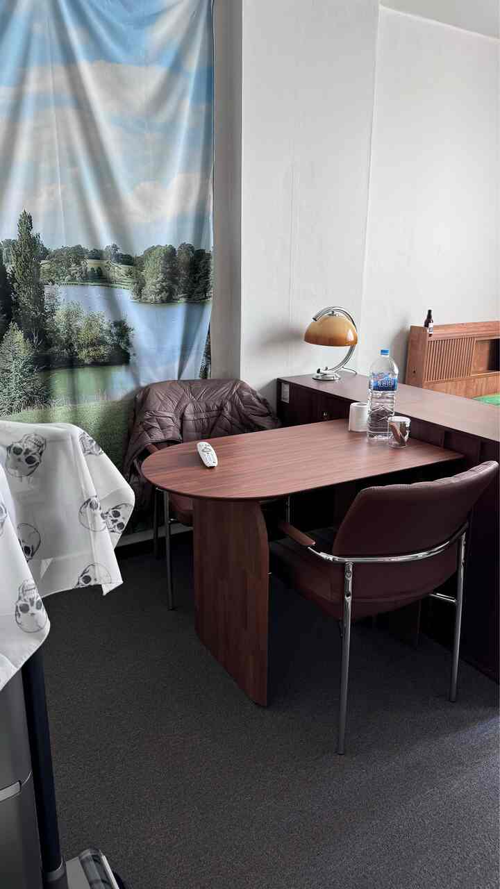 ブラウン調のコンパクトな部屋、机とオフィスチェアが配置されたモダンな空間