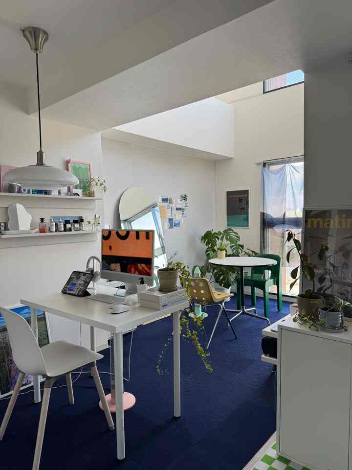 White and blue toned studio apartment featuring desk, dining table, and plants with a modern cozy home office vibe