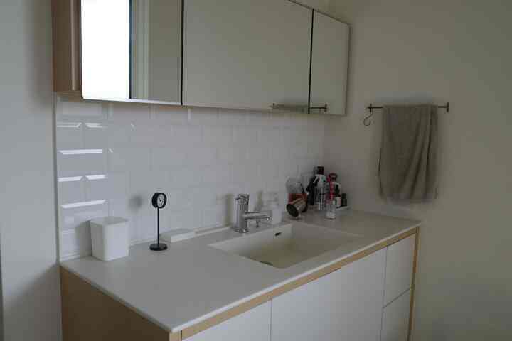 白を基調としたナチュラルモダンな洗面所、洗面台と収納が整った印象的な空間