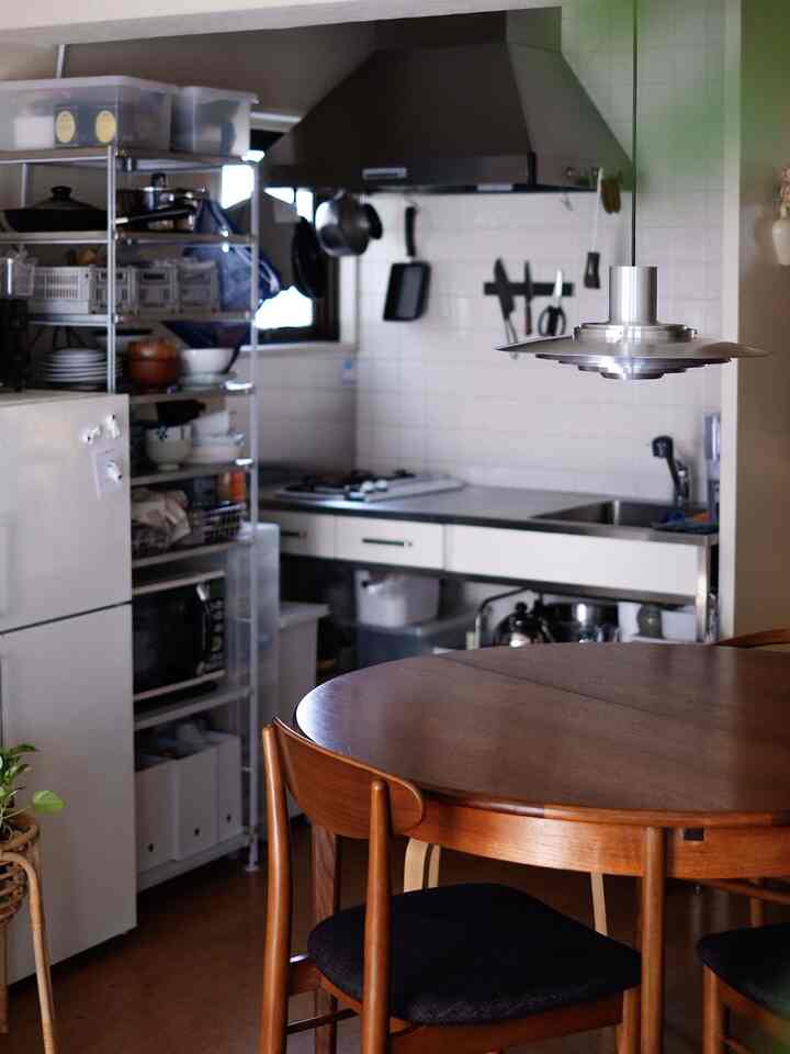 Natural wood tone dining table and white tiled kitchen in a cozy kitchen space