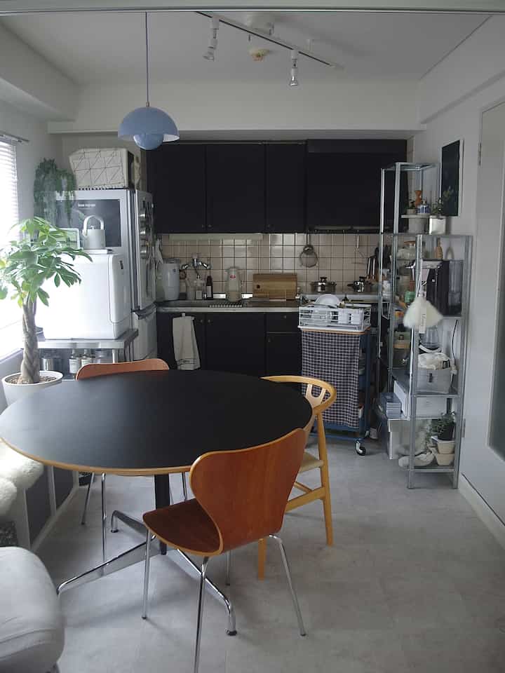 ブラックとナチュラルカラーの1人暮らしダイニング、植物と整理された収納がある印象的な空間