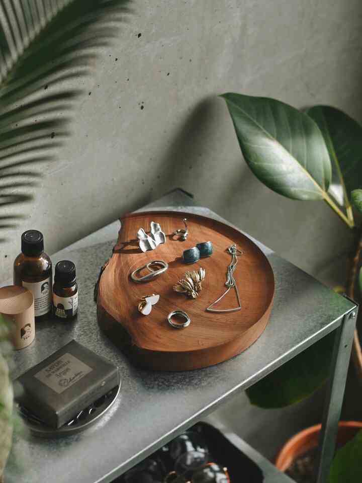 ナチュラルカラーのリビング、コンクリート壁と金属棚に木製小物やインテリア小物が配置された雰囲気のあるインテリア