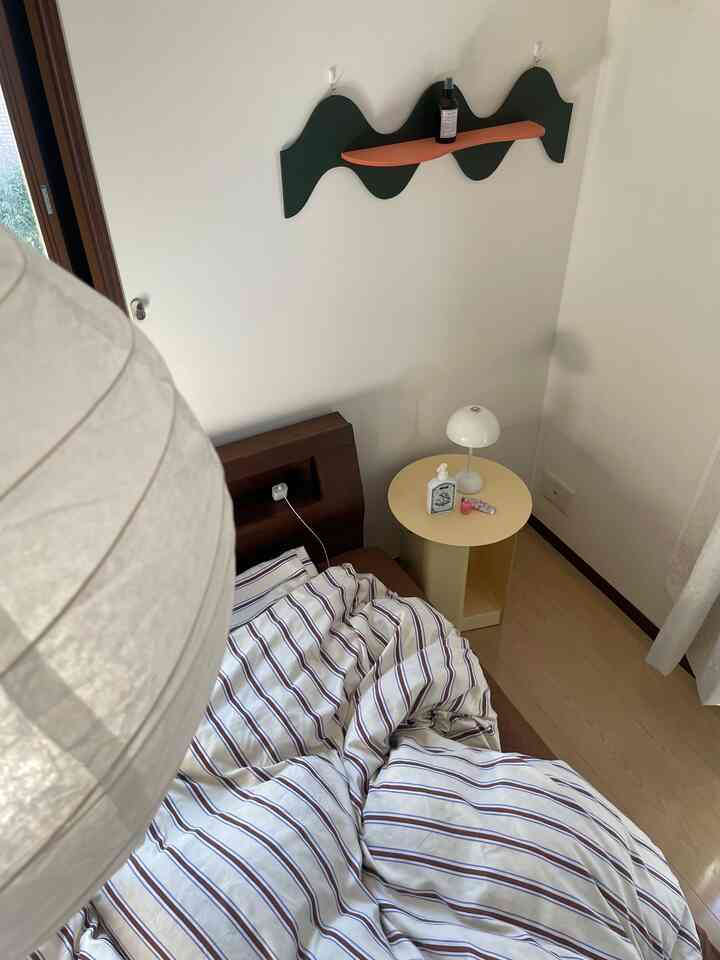 Compact natural modern bedroom corner with a yellow side table and brown bed