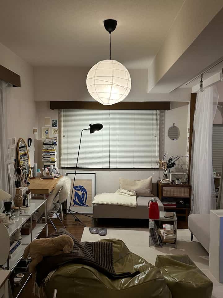 ベージュとブラウンの木目調が調和した小さなリビング、デスクとソファが配置されたナチュラルモダンな空間