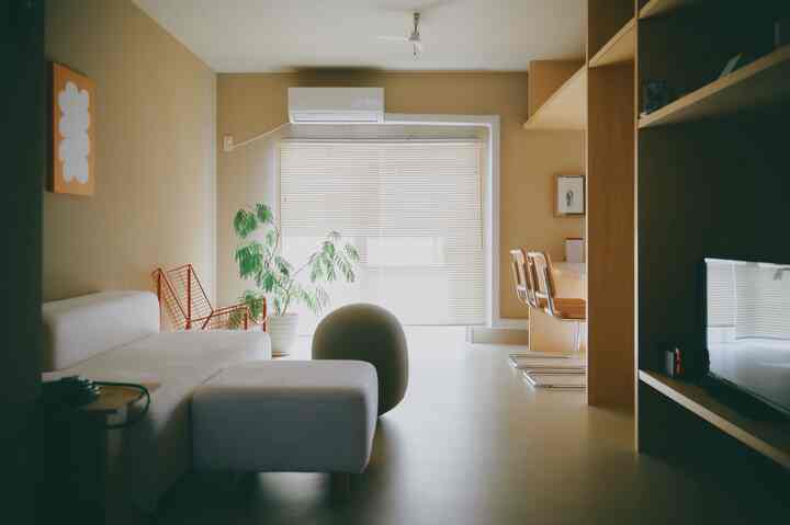 ベージュと白を基調としたリビング、ソファと木目調家具が配置された自然でシンプルなインテリア
