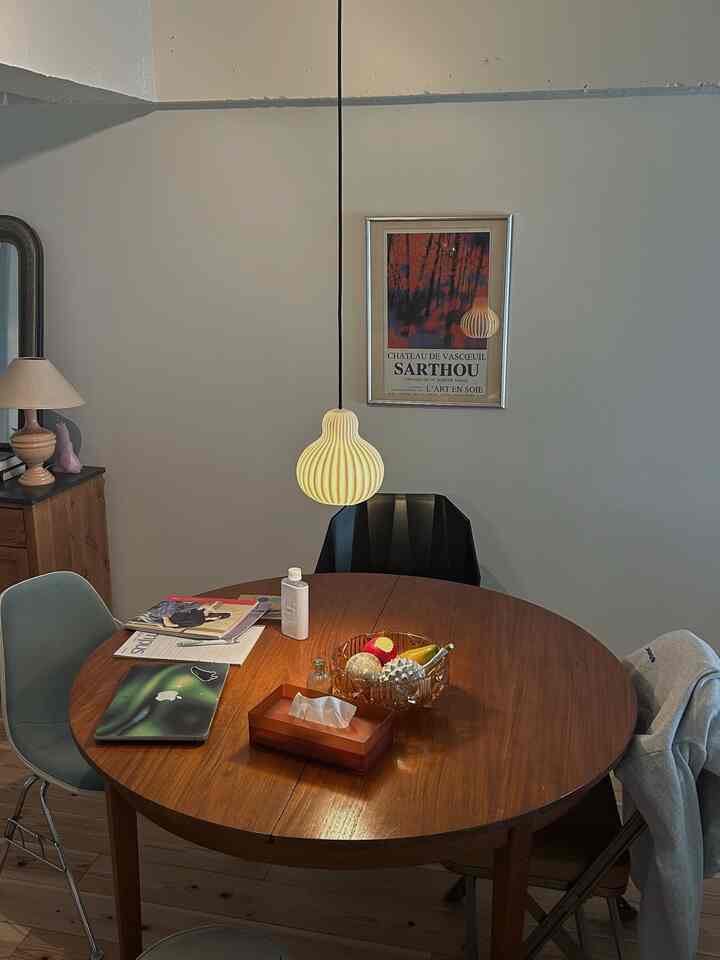 Natural-toned dining room featuring a round wooden table and varied chairs in a cozy setting