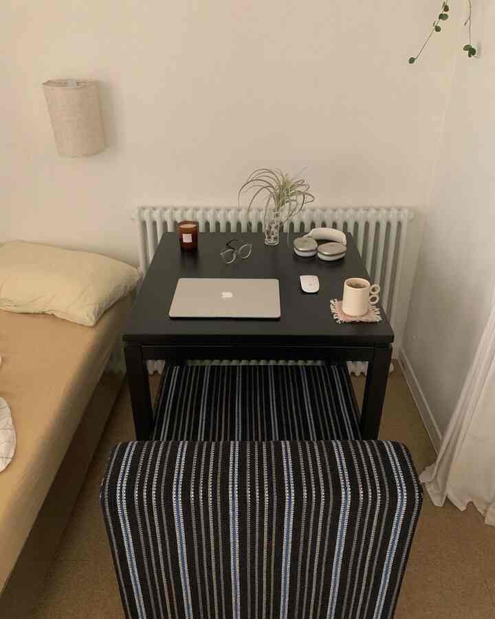 ブラックカラーの寝室にコンパクトに配置されたデスクと寝具があるモダンな空間