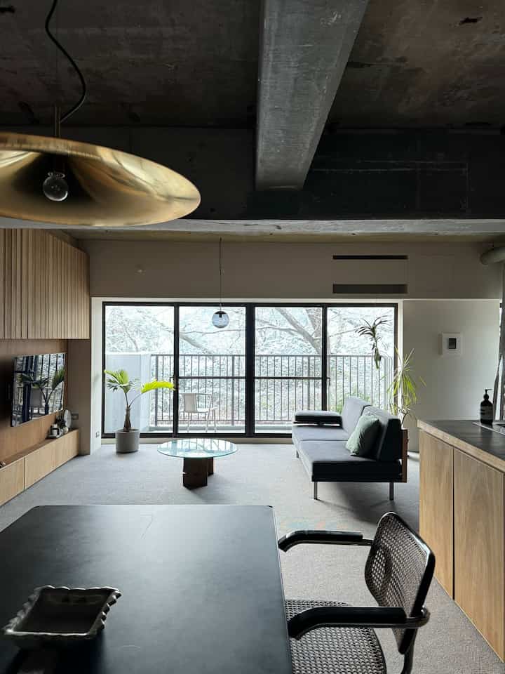 ナチュラルトーンと木目調のリビングルーム、雪景色のバルコニーと植物がある雰囲気のあるヴィンテージ空間