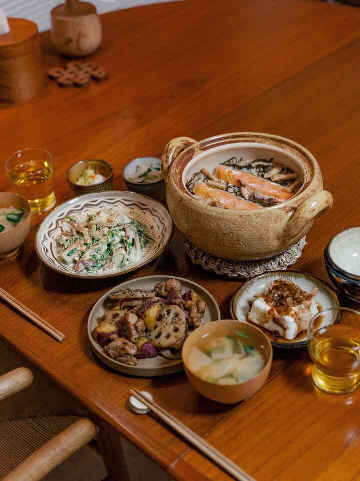 暖かみのある木目調のダイニングルーム、ナチュラルな陶器のテーブルウェアが配置された雰囲気のあるインテリア