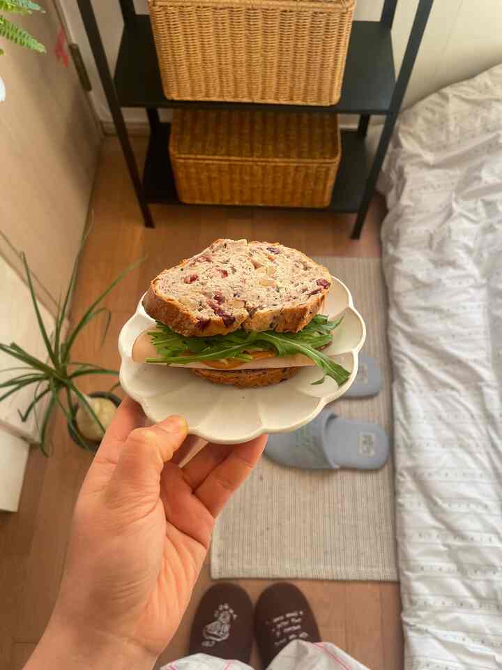 ナチュラルな色調のワンルーム寝室、収納棚と暖かみのある寝具が配置された印象的な空間