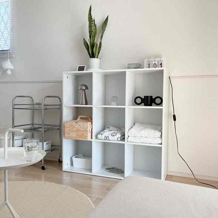 Natural and white-toned living space featuring a central open shelf and side table with a clean, minimalistic atmosphere