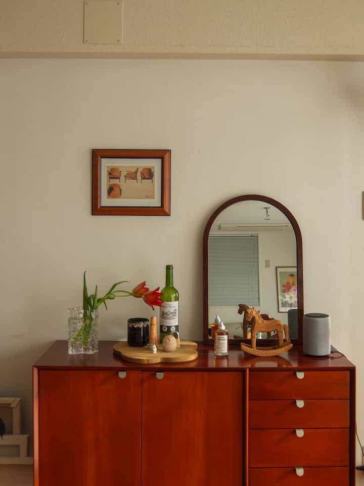 Warm brown wood tones and red flowers in a mid-century modern living room space