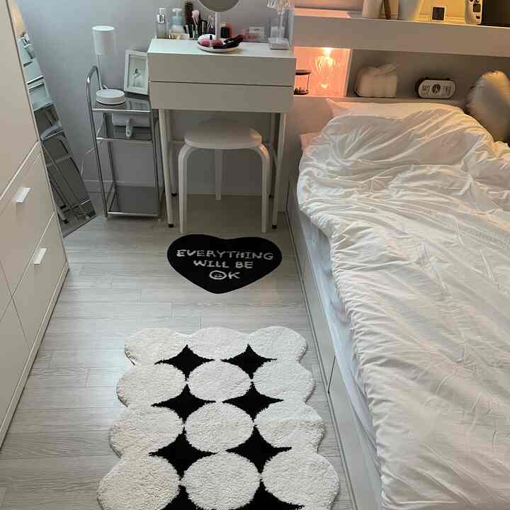 White-toned single household bedroom featuring a small desk and nightstand with a simple, compact design
