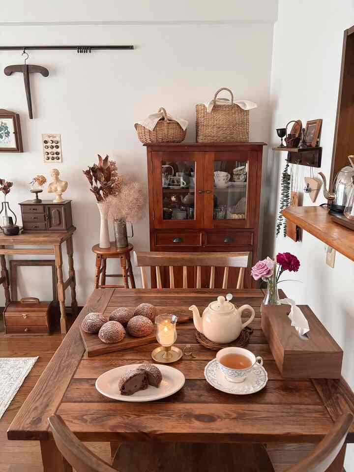 温かみのあるブラウン調のダイニングルーム、ヴィンテージ家具とおうちカフェセットが配置された雰囲気のあるインテリア