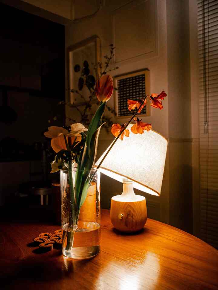 暖かみのある木目調のテーブルランプと花瓶が配置された北欧風の落ち着いたダイニングルーム