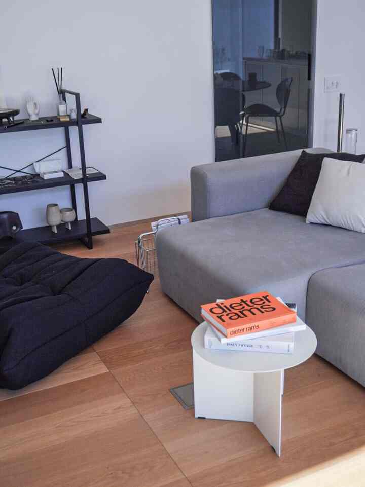 Simple living room with wood-tone flooring and gray modern sofa