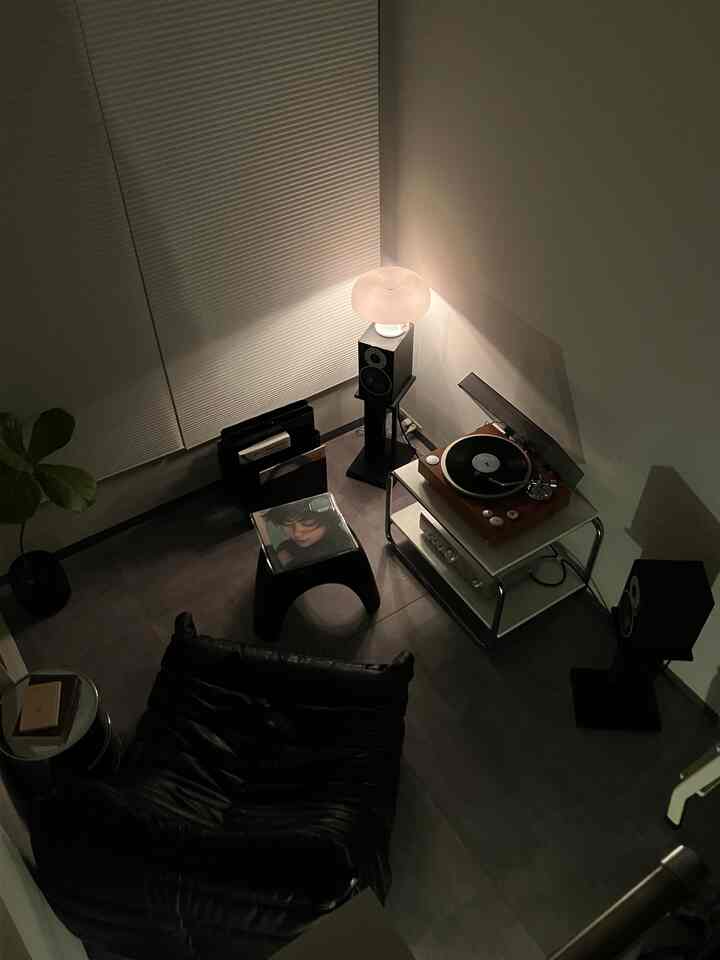黒と白のトーンのリビング、ソファとレコードプレーヤーが配置された雰囲気のある音楽空間