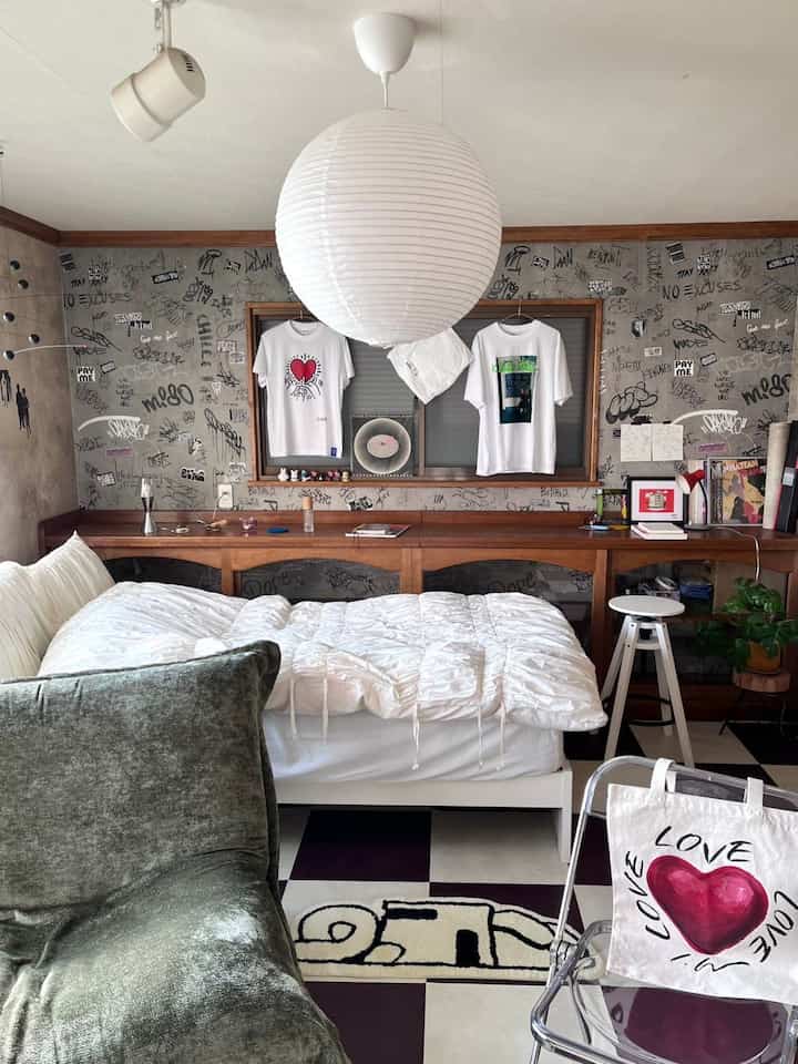 白と茶色のトーンの寝室、ミッドセンチュリーモダン家具とグラフィティ壁が配置された雰囲気のあるインテリア