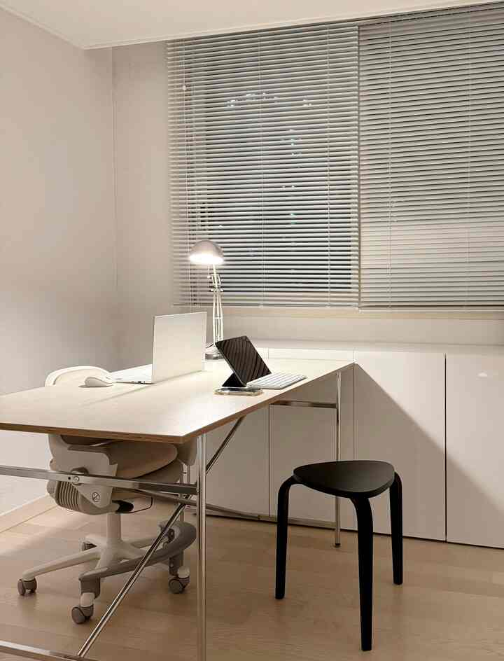 White and wood-toned study space featuring a desk and chairs, with a minimal and clean atmosphere