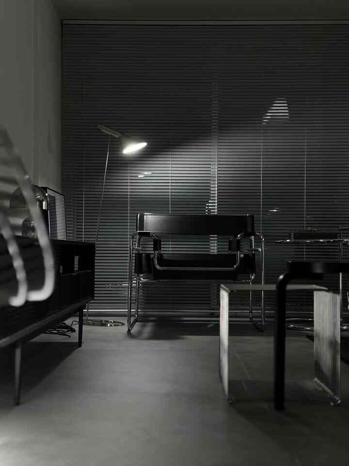 Modern industrial living room in black and silver tones featuring a Wassily chair and floor lamp at the center, elegant atmosphere