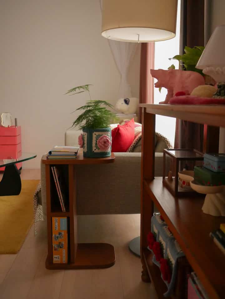 Natural color and brown wood tone living room featuring a storage side table and bookshelf creating cozy atmosphere