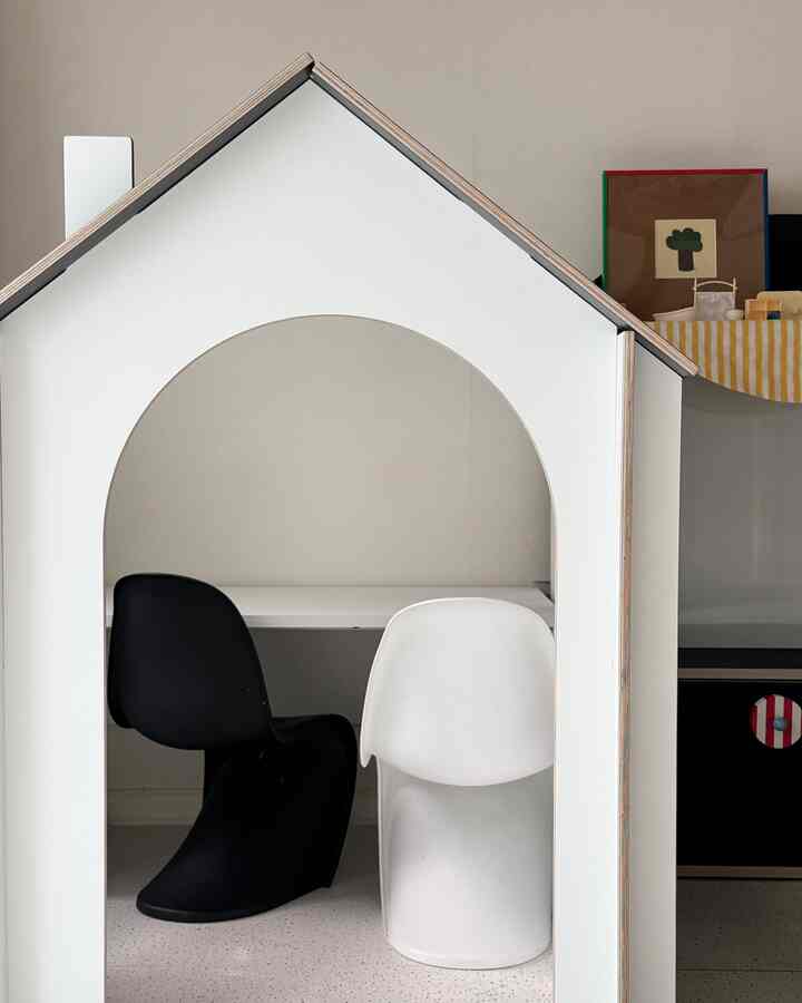 白と黒の色調の子供部屋、家の形のデスクと椅子が配置されたモダンで清潔感のあるインテリア