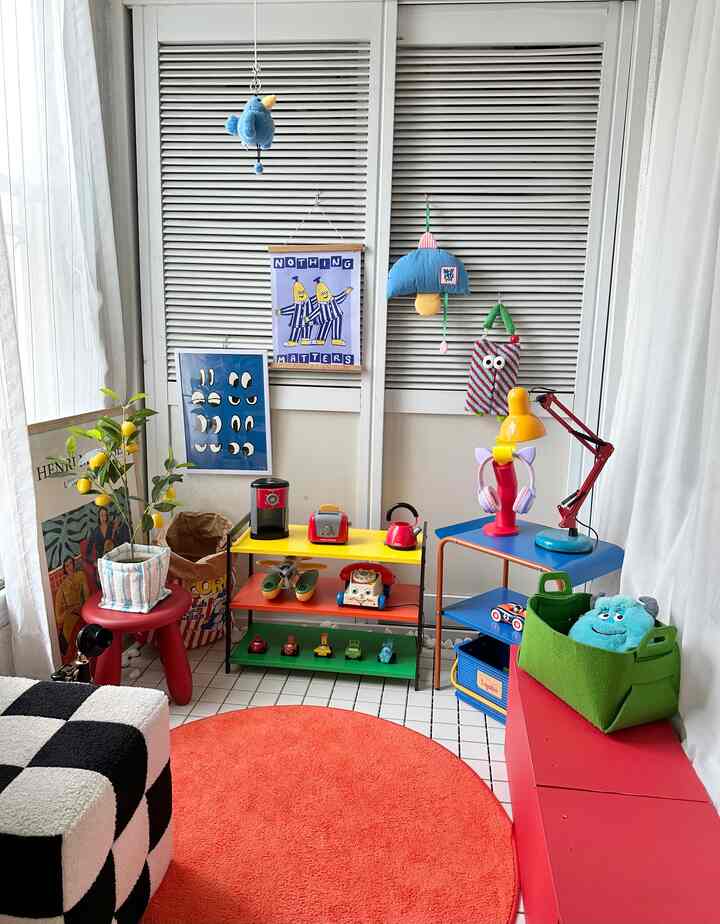 A vibrant veranda terrace space decorated with dominant red and blue tones, featuring baby toys and bright accessories