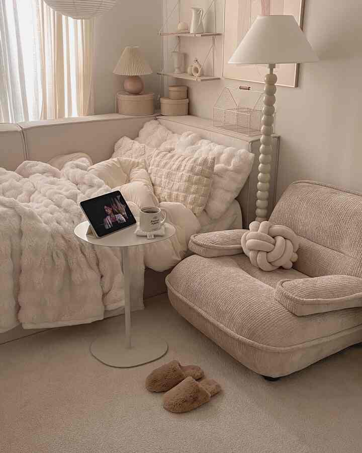 ナチュラルな色調のリビングルーム、ベージュのソファと暖かいブランケットが配置された雰囲気のあるインテリア