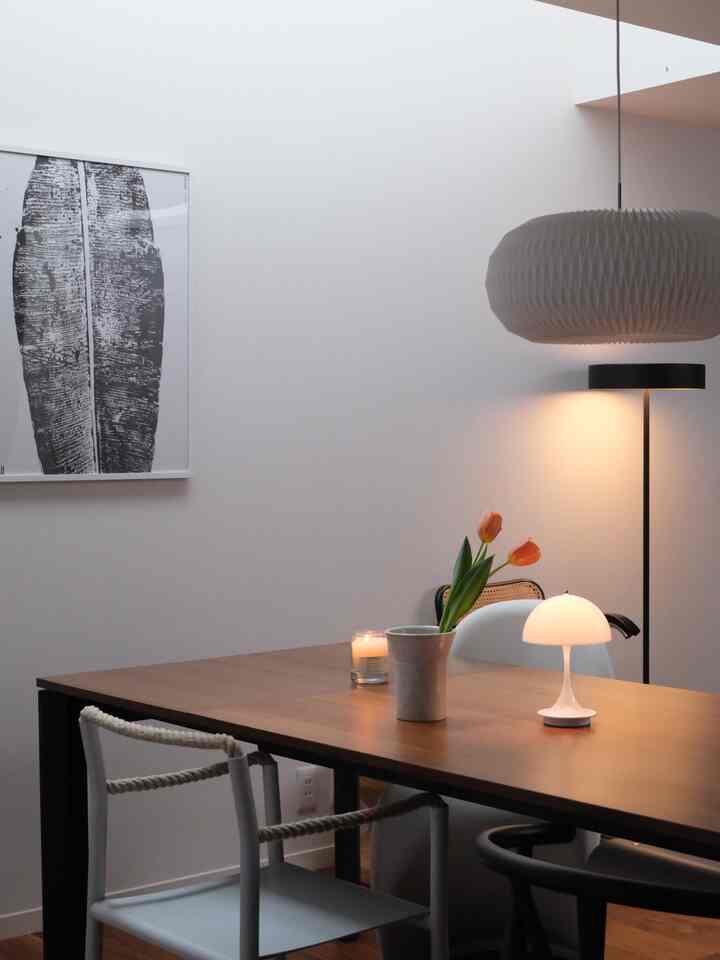 白い壁とブラウンのダイニングテーブル、様々な椅子が配置されたナチュラルで落ち着いたダイニング空間