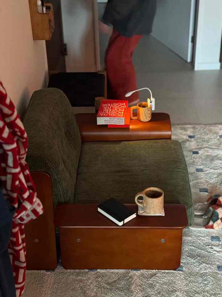 ブラウンの木製テーブルとオリーブグリーンのベルベットソファが配置された落ち着いたリビング