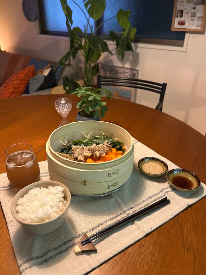 Warm wood tone dining table with natural color table runner, Japanese tableware, and tea cup in a cozy kitchen space
