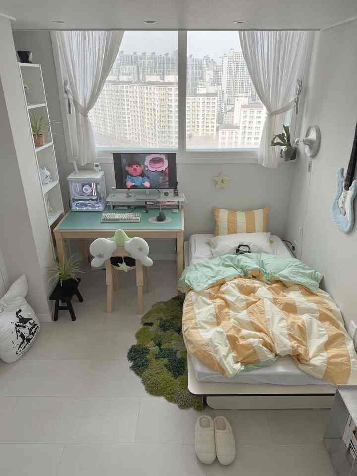 白とミント色調のワンルーム寝室、デスクとベッドが配置された落ち着いた印象の空間