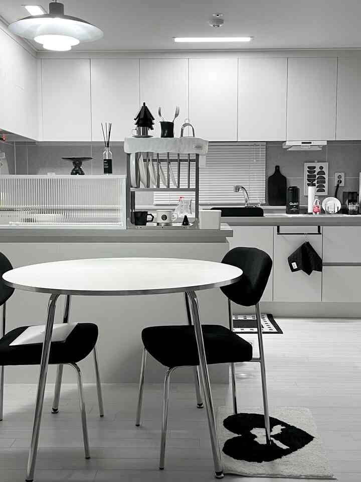 Monotone white and black kitchen and dining room with round dining table and chairs creating a clean and modern atmosphere