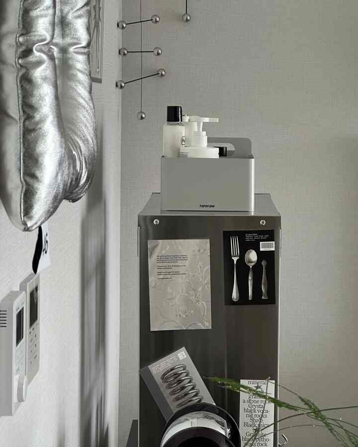 Silver-toned kitchen space featuring metallic items and a mobile decoration with modern interior design