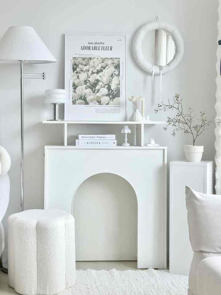 White tone living room photo zone featuring floral poster, stool, and decorative objets in a stylish setup