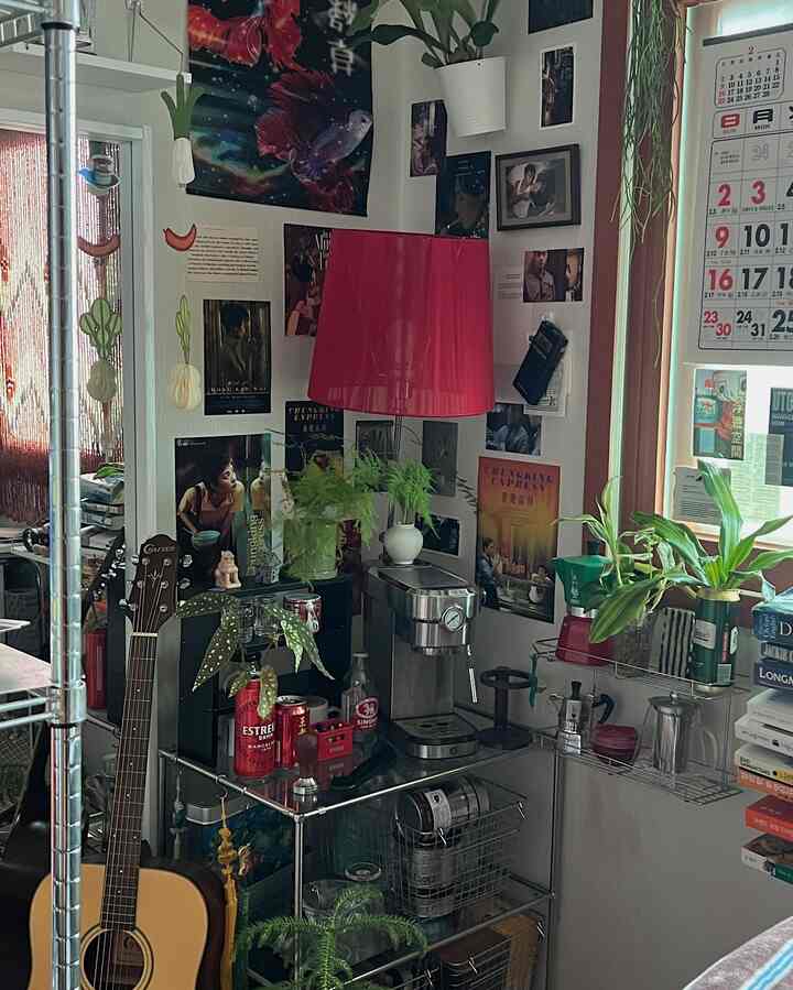 赤い照明とレトロポスターが調和する小さなホームカフェ空間、コーヒーマシンと植物が配置された居心地の良いインテリア