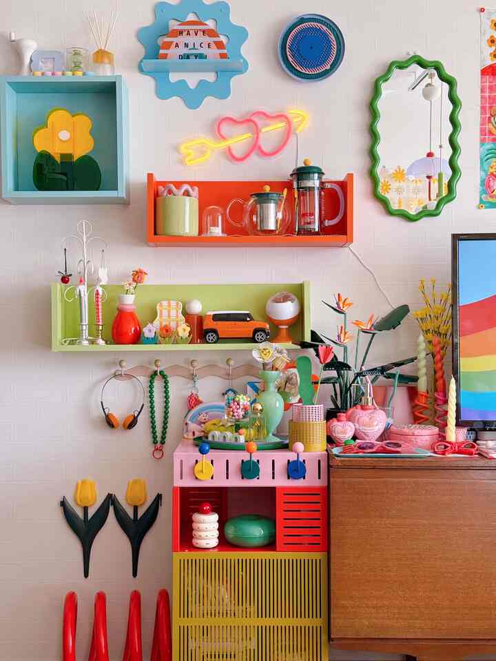 カラフルなリビングの壁、鮮やかな棚とネオンハートライトが配置された印象的な空間