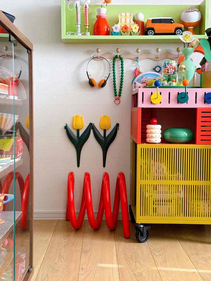 Bright and colorful small room featuring a multipurpose storage cabinet filled with toys and decorative items creating a playful atmosphere
