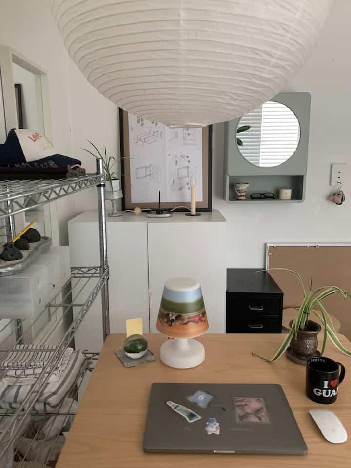 白と木目調が調和したモダンなホームオフィス、机の上にランプとノートパソコンが置かれた整った作業環境