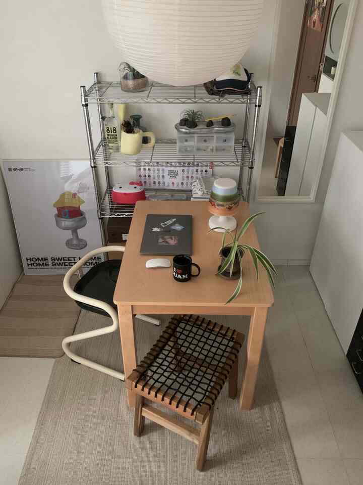 白い壁と木目調の家具が配置された一人暮らし向けのコンパクトな多目的空間