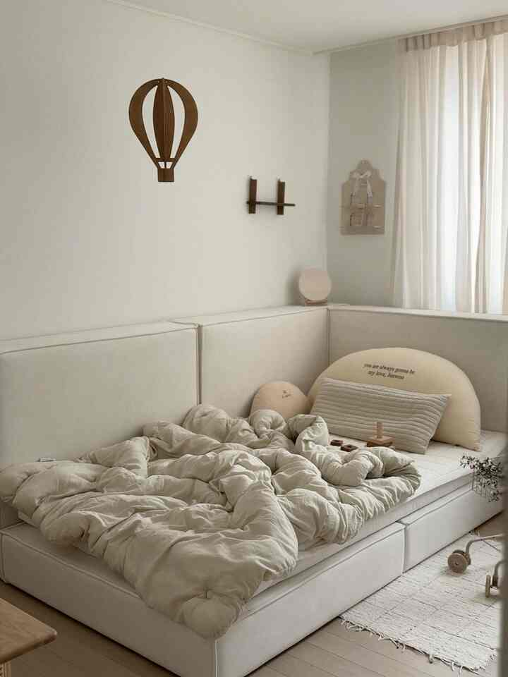 アイボリーの色調の子供部屋、オーダーメイドのベッドと柔らかな寝具が配置されたシンプルで上品なインテリア