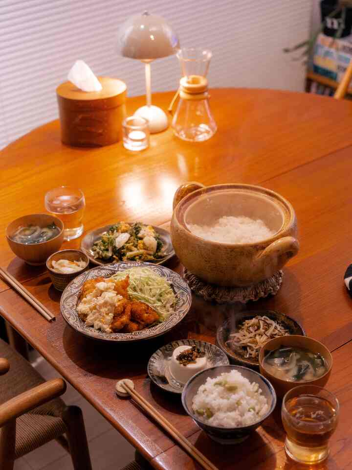 ブラウンの木目調ダイニングルーム、伝統的な陶器の鍋と器が配置された温かみのある食卓空間