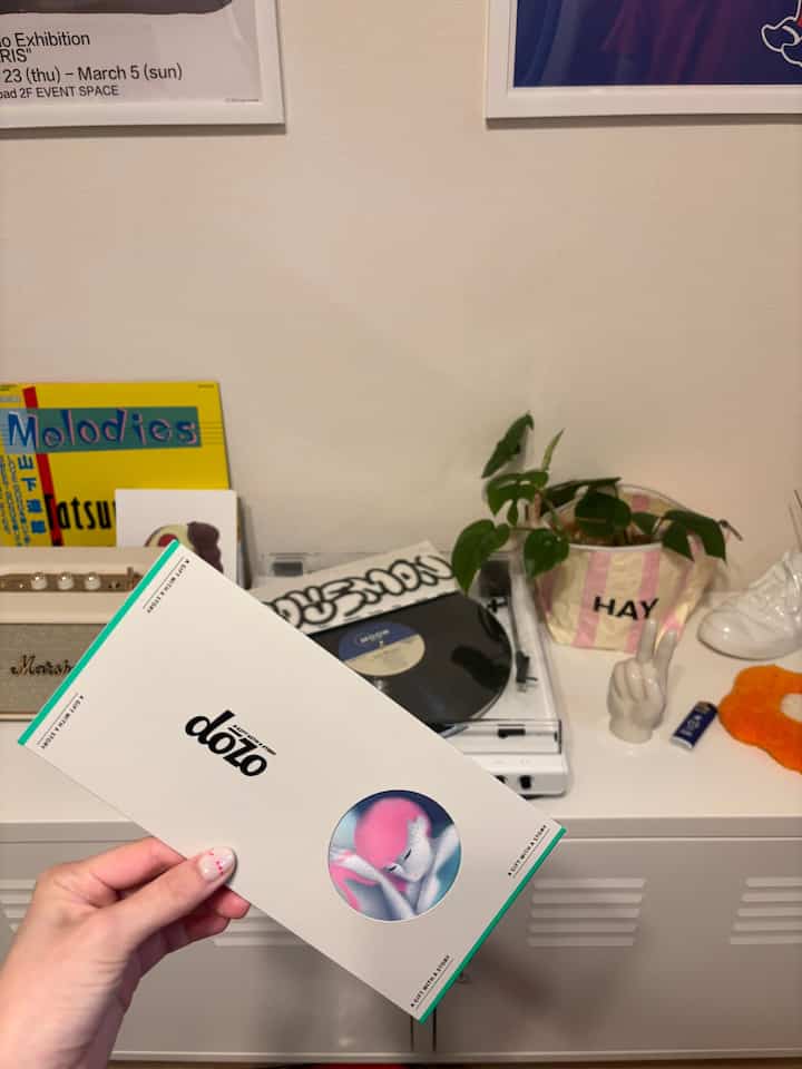 White wall and storage cabinet living room featuring retro audio equipment and decorative objets with cozy atmosphere