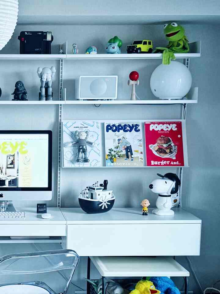 白色のコンパクトなホームオフィス、机と棚に様々なオブジェや本が配置されたシンプルで印象的なインテリア